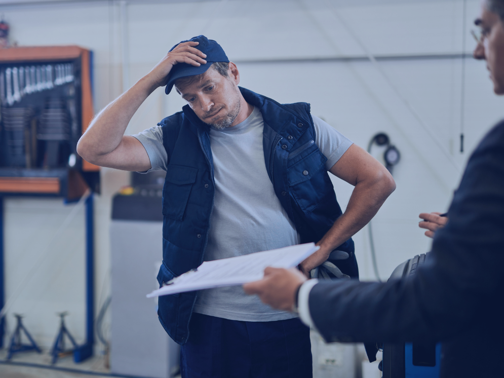 Un salarié semble préoccupé lors d’un échange professionnel, une situation qui illustre les risques psychosociaux au travail comme le stress, la fatigue et la pression organisationnelle.
